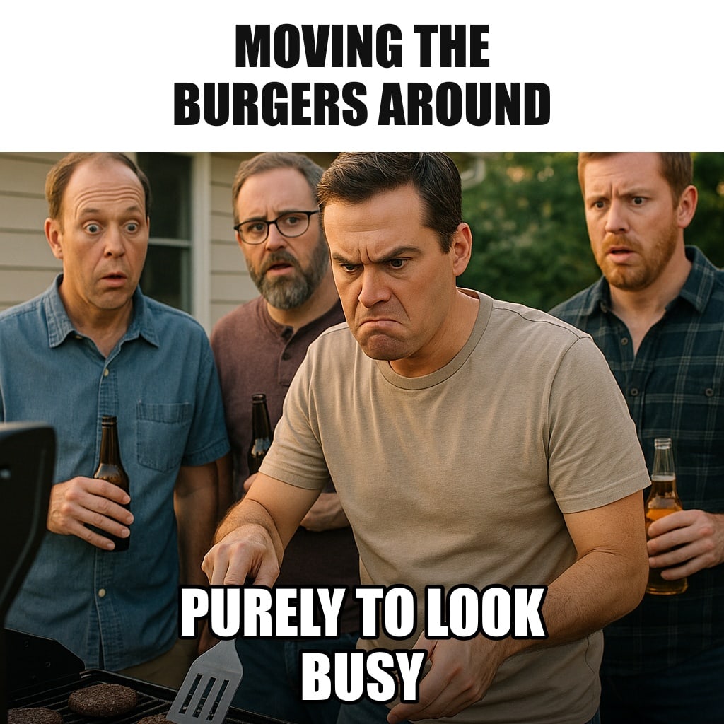A man at a backyard grill flipping and sliding burgers with a spatula with great seriousness, as three other men stand beside him watching intently with drinks. Caption: "Moving the burgers around Purely to look busy"