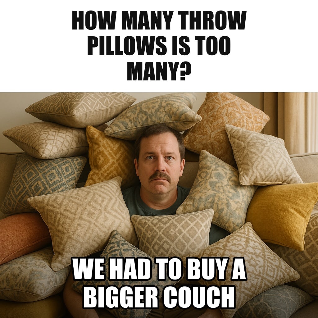 A living room couch completely buried under dozens of decorative throw pillows, a husband peeking out from between them, deadpan. Caption: "How many throw pillows is too many? We had to buy a bigger couch"