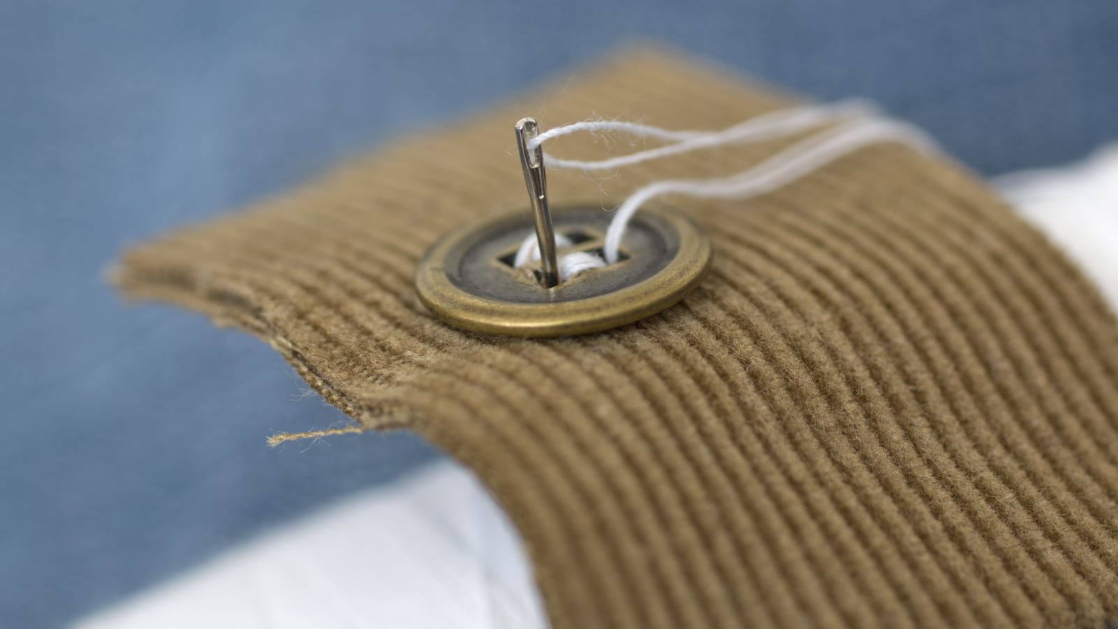 Sew on a button and mend a seam so they stay fixed